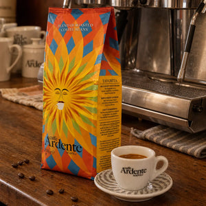 Caffè Ardente Favorita, 250g Kaffeebohnen in orange-blau-gelber Sonnenmotiv-Verpackung, mit Espressotasse an der Siebträgermaschine