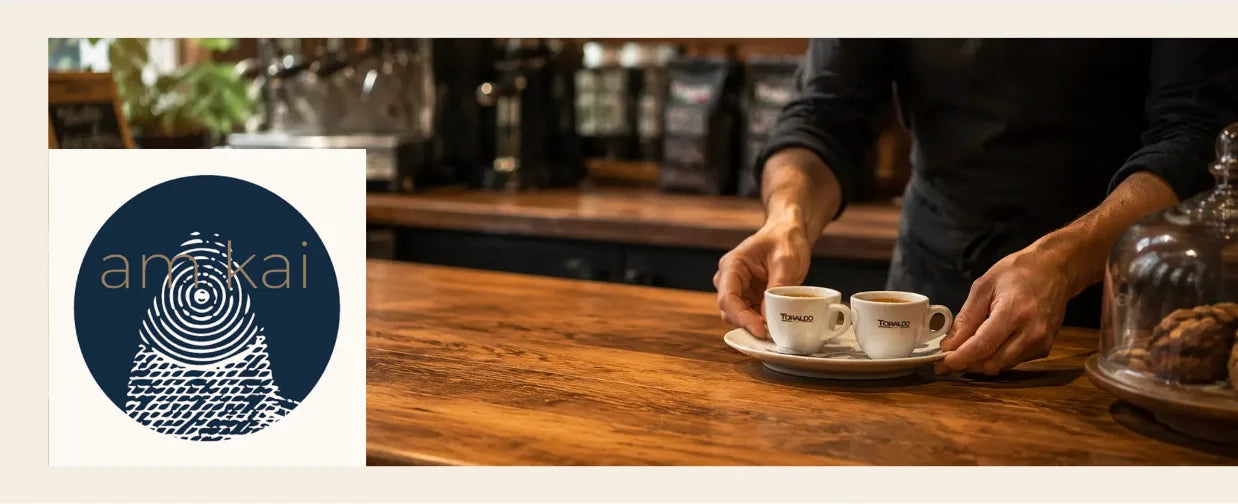 Am Kai Logo links, rechts im Bild hält eine Frau eine Tasse Espresso in den Händen