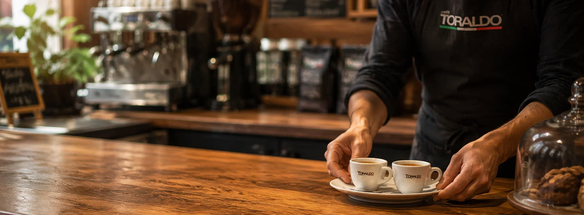 Toraldo Espresso Tasssen auf dem Tresen, die von einem Barista bedient werden
