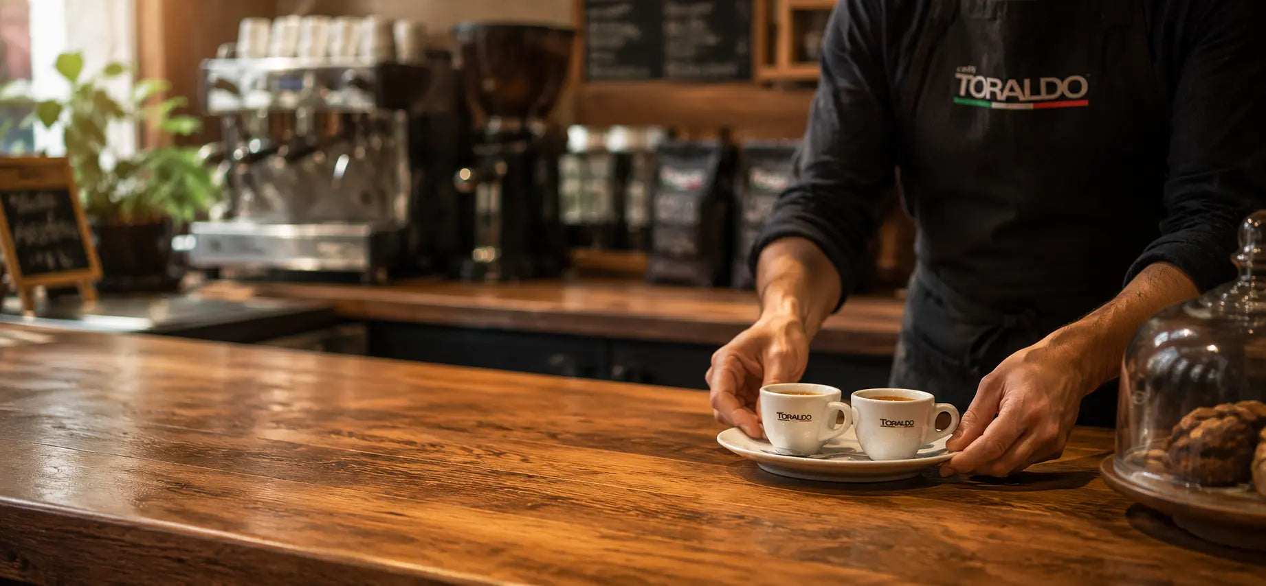 Kaffeebar Tresen mit einem Barista der 2 Espresso Tassen serviert