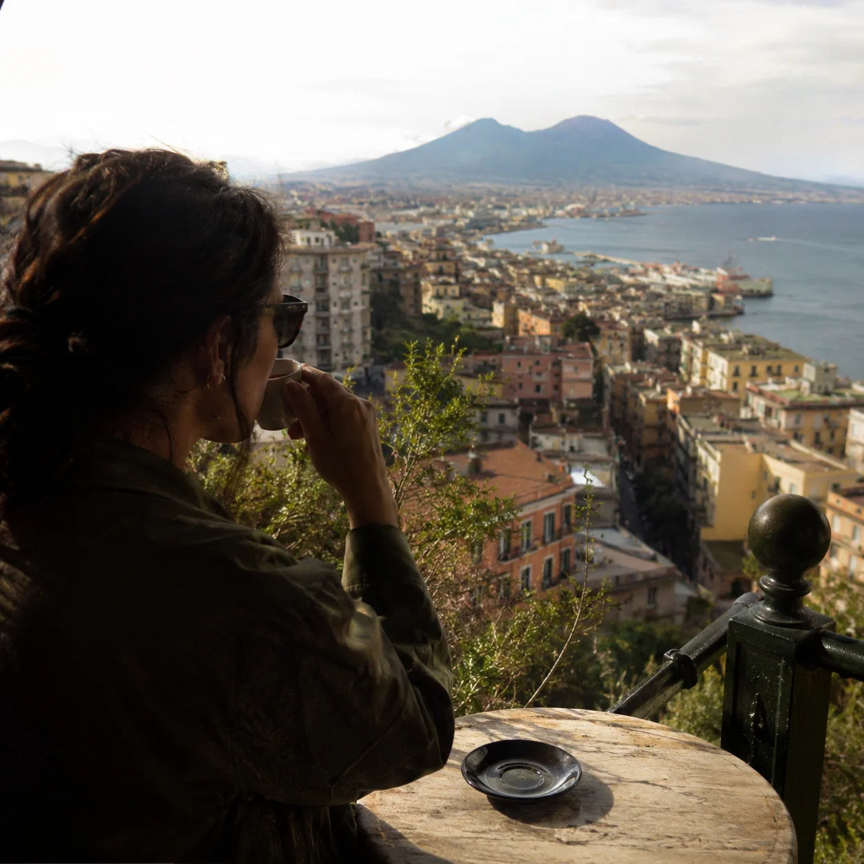 Frau die auf Napoli schaut mit einer Tasse Espresso in der Hand