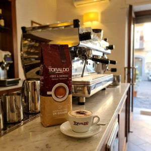 Caffè Toraldo Forte & Cremoso, Espresso Napoletano Kaffeebohnen mit Cappuccino auf Café-Theke vor der Siebträgermaschine