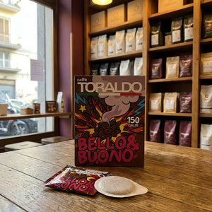 Caffè Toraldo Bello & Buono, 150 ESE-Pads-Packung mit einzelner Kaffeepad und Pad-Beutel auf Holztisch im Ladengeschäft