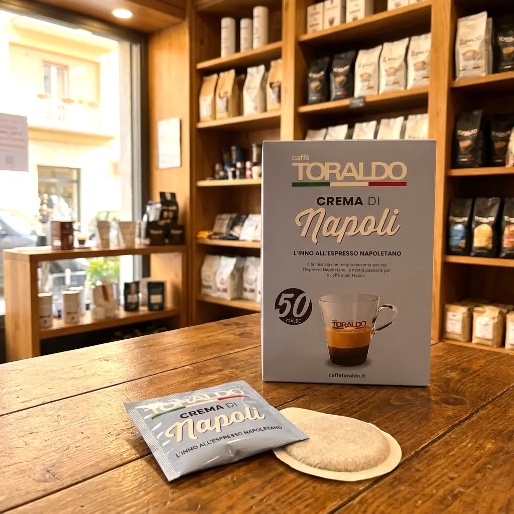 Caffè Toraldo Crema di Napoli, 50 ESE-Pads-Packung mit einzelnem Pad-Beutel und Kaffeepad auf Holztisch im Ladengeschäft