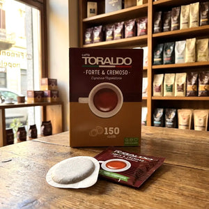 Caffè Toraldo Forte & Cremoso, 150 ESE-Pads-Packung mit einzelnem Pad-Beutel und Kaffeepad auf Holztisch im Ladengeschäft